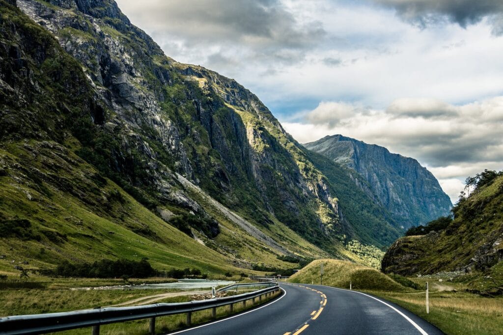 gray asphalt road between mountains